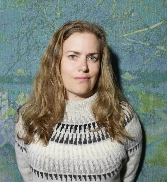 Portrett av kvinne med grå strikkegenser og langt hår 