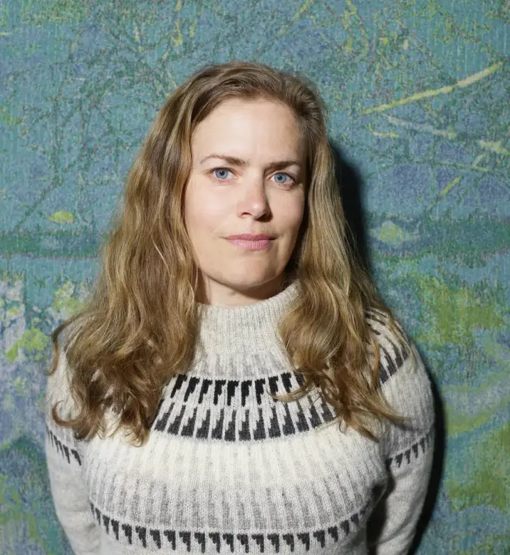 Portrett av kvinne med grå strikkegenser og langt hår 