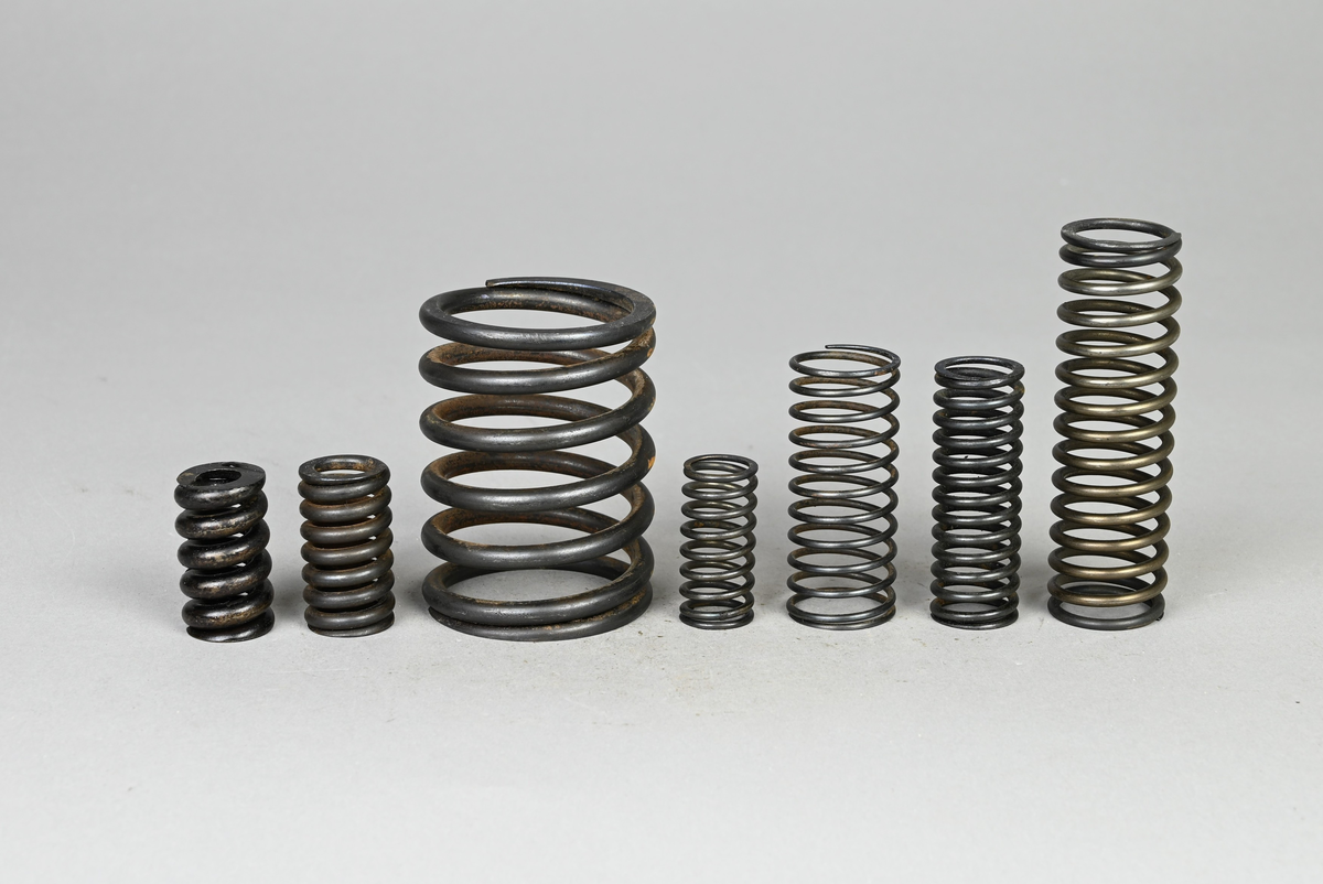 Sju prover på ventilspiralfjäder i olika storlekar. Sex av proverna även märkt med egen etikett med märkning 303-308. Tillhörande lapp med notering: "Diverse ventilspiralfjädrar för explosionsmotorer. Från A-B. Spiralfabriken."