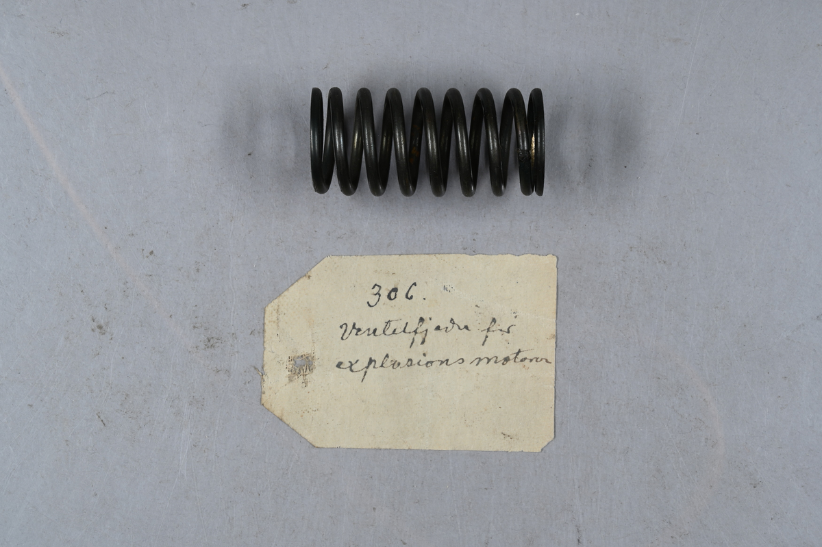Sju prover på ventilspiralfjäder i olika storlekar. Sex av proverna även märkt med egen etikett med märkning 303-308. Tillhörande lapp med notering: "Diverse ventilspiralfjädrar för explosionsmotorer. Från A-B. Spiralfabriken."