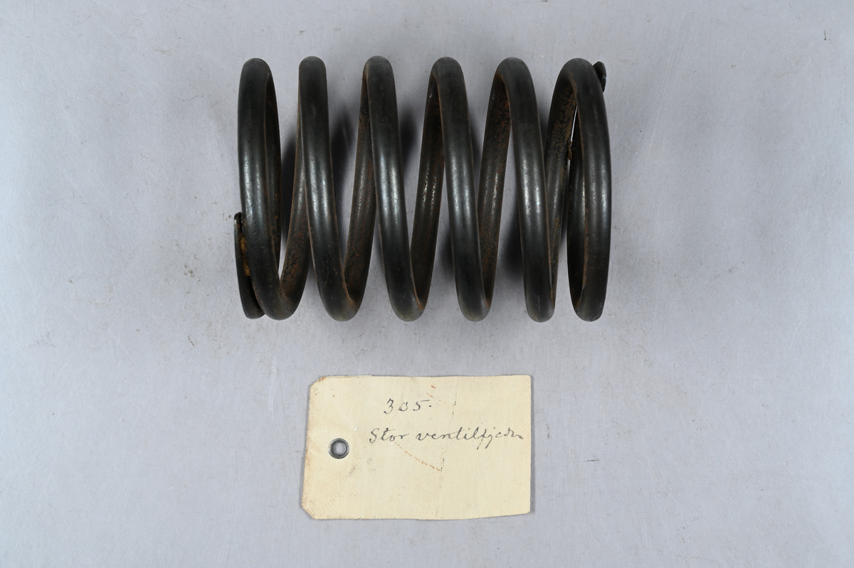 Sju prover på ventilspiralfjäder i olika storlekar. Sex av proverna även märkt med egen etikett med märkning 303-308. Tillhörande lapp med notering: "Diverse ventilspiralfjädrar för explosionsmotorer. Från A-B. Spiralfabriken."