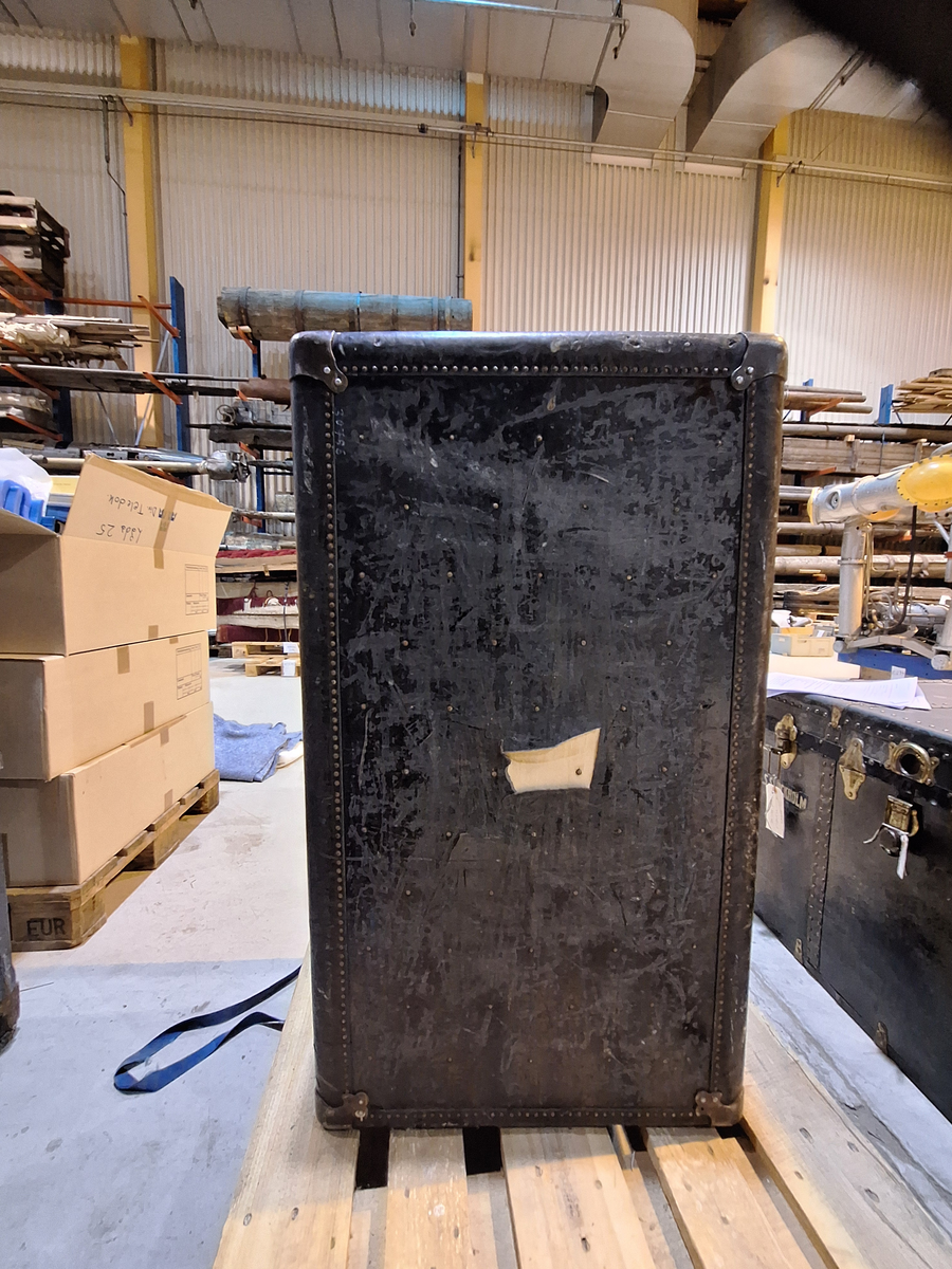 Inredd koffert som tillhört postorderkungen Oscar Ahrén (1881-1948). Kofferten är inredd med galghängare och lådor. På utsidan klistermärken från olika delar av världen.