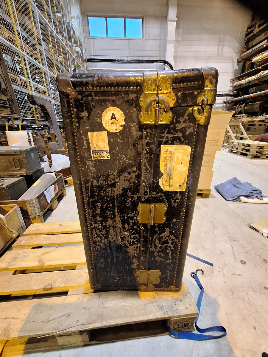 Inredd koffert som tillhört postorderkungen Oscar Ahrén (1881-1948). Kofferten är inredd med galghängare och lådor. På utsidan klistermärken från olika delar av världen.