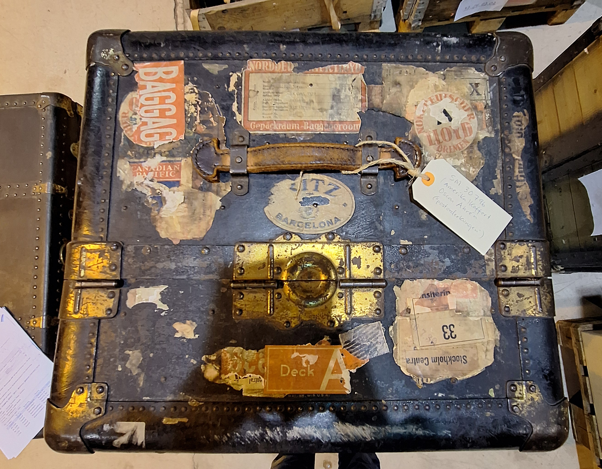 Inredd koffert som tillhört postorderkungen Oscar Ahrén (1881-1948). Kofferten är inredd med galghängare och lådor. På utsidan klistermärken från olika delar av världen.