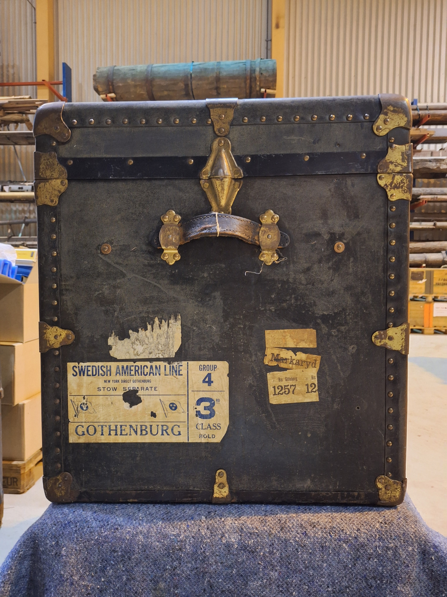 Koffert. 
Fodrad med blåblommig papp på beige botten. Fläckad i botten. Två trälister längs kortsidan ca 100 mm från locket.