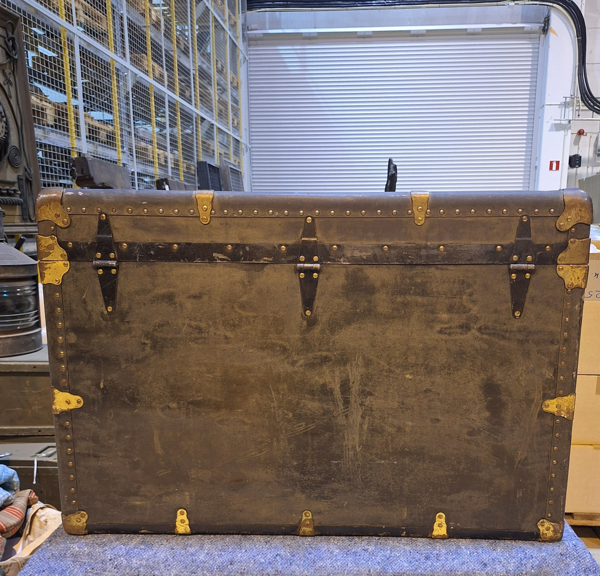 Koffert. 
Fodrad med blåblommig papp på beige botten. Fläckad i botten. Två trälister längs kortsidan ca 100 mm från locket.