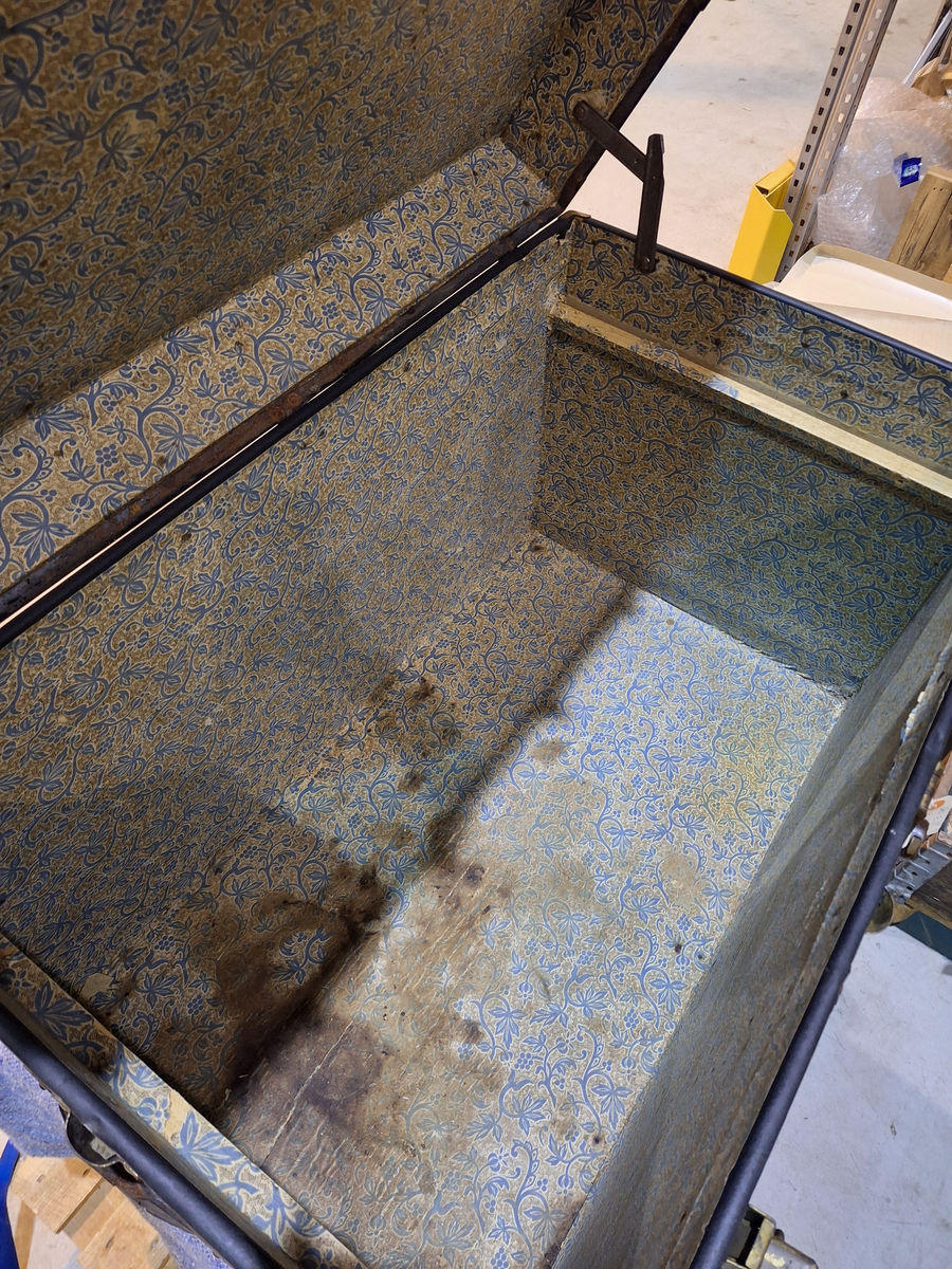 Koffert. 
Fodrad med blåblommig papp på beige botten. Fläckad i botten. Två trälister längs kortsidan ca 100 mm från locket.