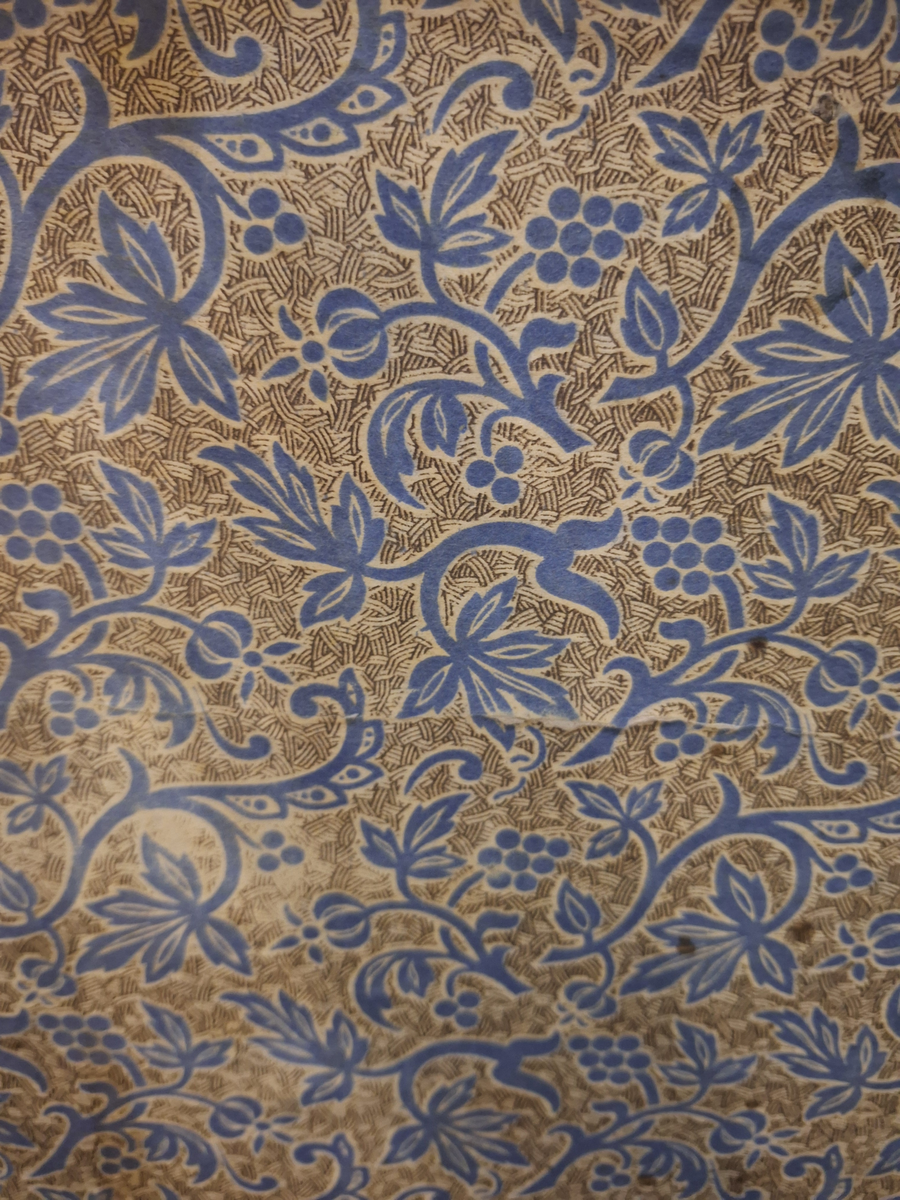 Koffert. 
Fodrad med blåblommig papp på beige botten. Fläckad i botten. Två trälister längs kortsidan ca 100 mm från locket.