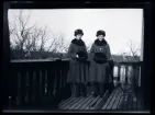 Systrarna Elsa och Gudrun i likadana ytterkläder, porträtterade på balkongen till familjen Morthensens villa Solveden, Djursholm.