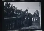 Elin Morthensen (född Anrep) porträtterad i hatt med fjäder, på balkongen till familjen Morthensens villa Solveden, Djursholm.