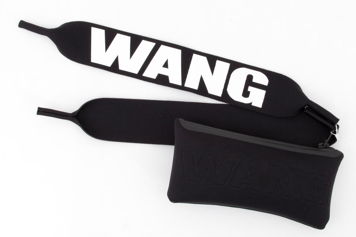 Relativt store, men lette solbriller av matt, svart plast. Mens innfatningen er i hardplast, virker stengene gummiert i overflaten. Stengene er brede og gjennombrudt i fremre del, og utfylt med WANG i store bokstaver. Plastglassene er mørke og gråfiolette. Brilleetuiet er av tynt, neoprenlignende materiale, med gummiert plastglidelås. Den ene siden har bokstavene WANG trykket ned i materialet, mens den andre siden har teksten ALEXANDER WANG x H&M i forhøyet gummitrykk. Brillesnorer, to stykker av neopren, til å tre innpå stengene, den ene pålimt navnet WANG i hvite plastbokstaver, den andre WANG i svarte bokstaver.