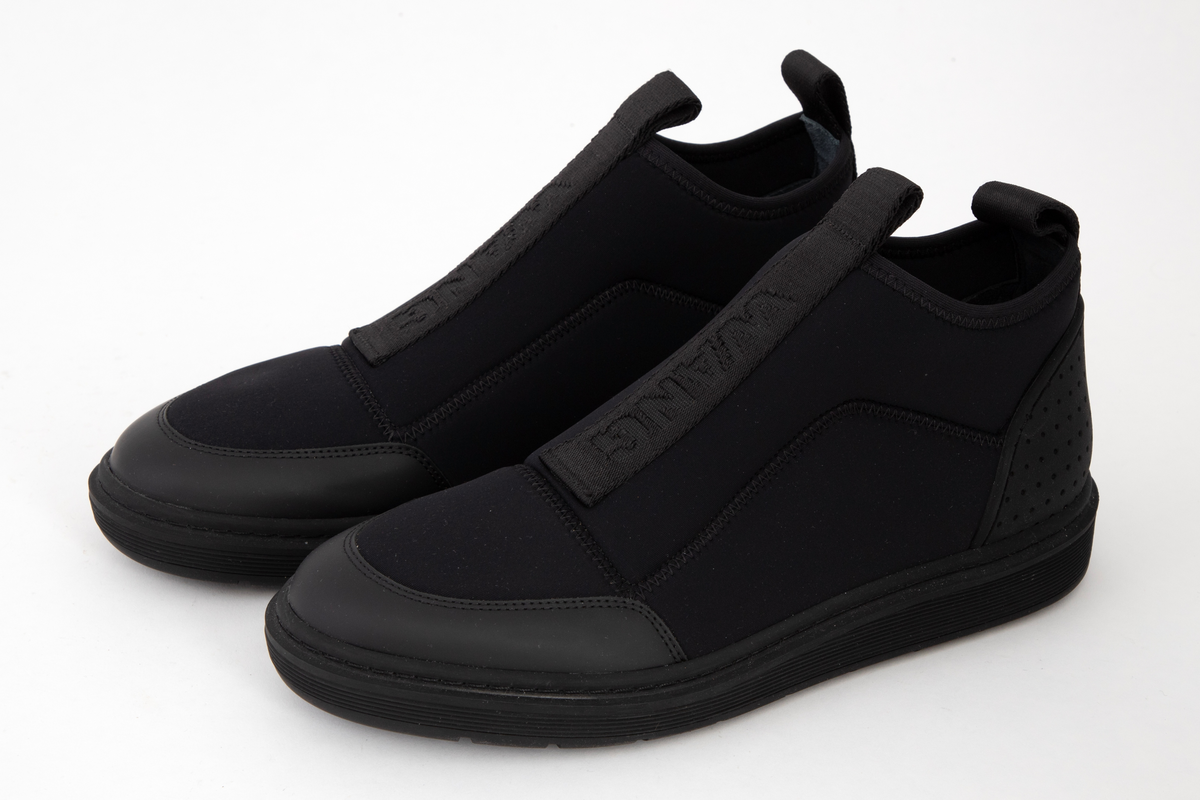 Herresko i svart neopren og gummi, avrundet foran og med påsydd bånd med hempe midt foran og bak, foran med innvevd logo: WANG. Kraftig profilert såle med bokstavene WA etter hverandre.