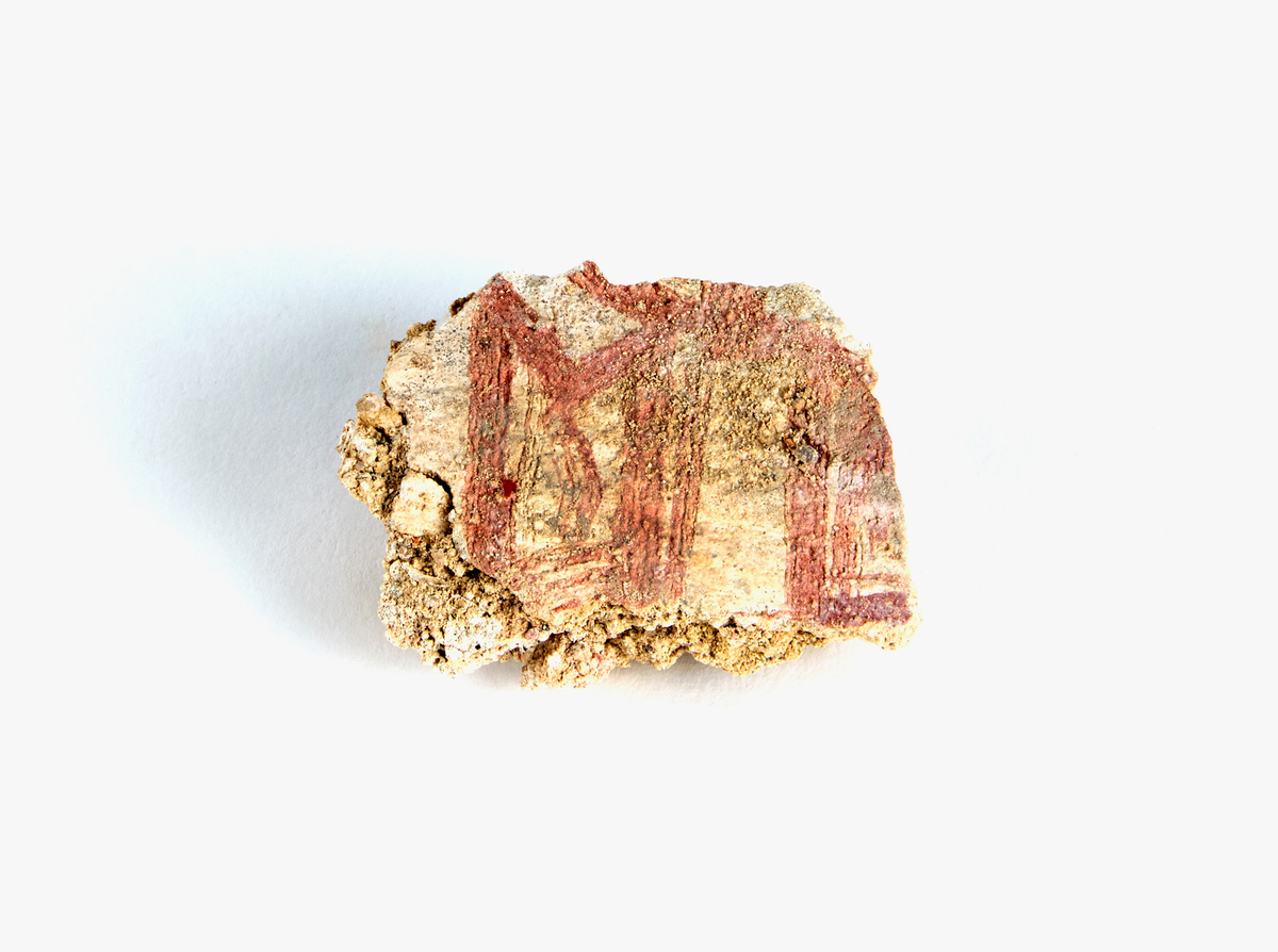 En samling av fragment av målad puts och bruk med kalkputs och bemålning. 17 fyndaskar med fragment i olika storlekar.

Fyndask 1: Totalt 13 fragment med röd och vit färg, en ser ut att ha träavtryck (varit fäst mot ett trästycke).

Fyndask 2: Totalt 7 fragment alla utom en har röd och vit färg, endast en med gråaktig obehandlad puts. 

Fyndask 3: Totalt 1 större fragment med röd och vit färg på enda sidan.

Fyndask 4: Totalt 4 fragment alla utom en med röd och vit färg, endast en med vit puts. 

Fyndask 5: Totalt 3 fragment med röd och vit färg, varav en är sotig. 

Fyndask 6: Totalt 3 fragment med röd och vit färg, en mycket tydlig medan de andra två mer diffusa. 

Fyndask 7:  Totalt 27 fragment, 24 av dessa är bemålade med röd och vit färg, 3  fragment med gråaktig obehandlad puts. 

Fyndask 8: Totalt 5 fragment, varav 4 större och en mycket liten. Alla större fragment med olika karaktär. En med vit kalkbruk och utan putsad yta, en annan med svart och röd putsad yta. Det tredje fragmentet har lite rödfärgad puts bevarad och på andra sidan ser det ut att ha träavtryck (varit fäst mot ett trästycke). Det fjärde fragmentet har en mer brungrå nyans. I fyndasken låg en lapp med text N. om V. portalen. 

Fyndask 9: Totalt 13 fragment, varav ett större fragment med svart och rödmålad puts. Ett annat fragment med svart och vitmålad puts, det tredje fragmentet har endast svartmålad puts. Sedan finns tre rödmålande putsfragment, samt tre fragment med röda linjer. Fyra fragment är ytterst små och intetsägande.

Fyndask 10: Totalt 9 fragment samt smådelar varav två har rött färgfragment. Det största fragmentet samt fyra andra är svart- och rödmålat. Tre putsfragment har röda linjer.
 
Fyndask 11: Totalt 1 fragment med röda linjer samt en mindre del med blågråa linjer. 

Fyndask 12: Totalt 1 fragment med blågrå rundad linje samt samt en mindre punkt eller koncentration nedanför.  

Fyndask 13: Totalt 5 fragment varav två med rödmålad puts. De andra tre har linjer. 

Fyndask 14: Totalt 1 fragment med vit och rödmålad puts, med flertal linjer som eventuellt kan vara del av en bokstav.
 
Fyndask 15: Totalt 1 fragment med vit och svartmålad puts, med flertal linjer som eventuellt kan vara del av en större figur. Ena delen syns en större koncentration som skulle kunna vara en fågel. 

Fyndask 16: Totalt 1 fragment med vit och rödmålad puts, med flertal rundade linjer som eventuellt kan vara del av växtlig dekor.

Fyndask 17: Totalt 1 fragment med rödmålad puts, med en vit linje.