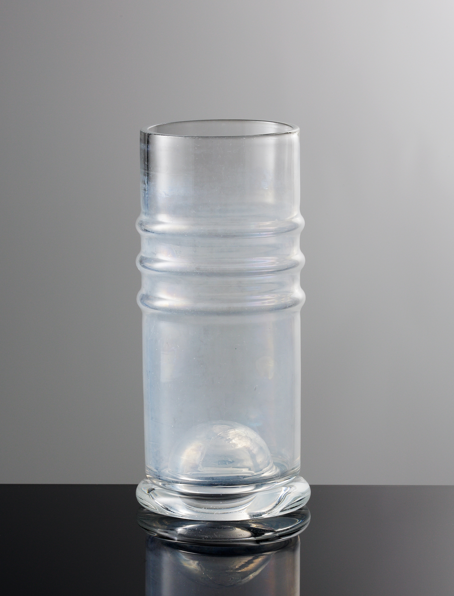 Vas med tre vulster och instick i botten. Vitdimmig yta på insidan.