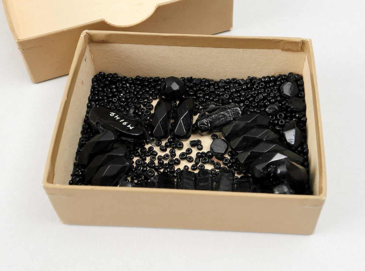 Armband och smyckesdelar/pärlor av stenkol.
Inskrivet i huvudbok 1936.