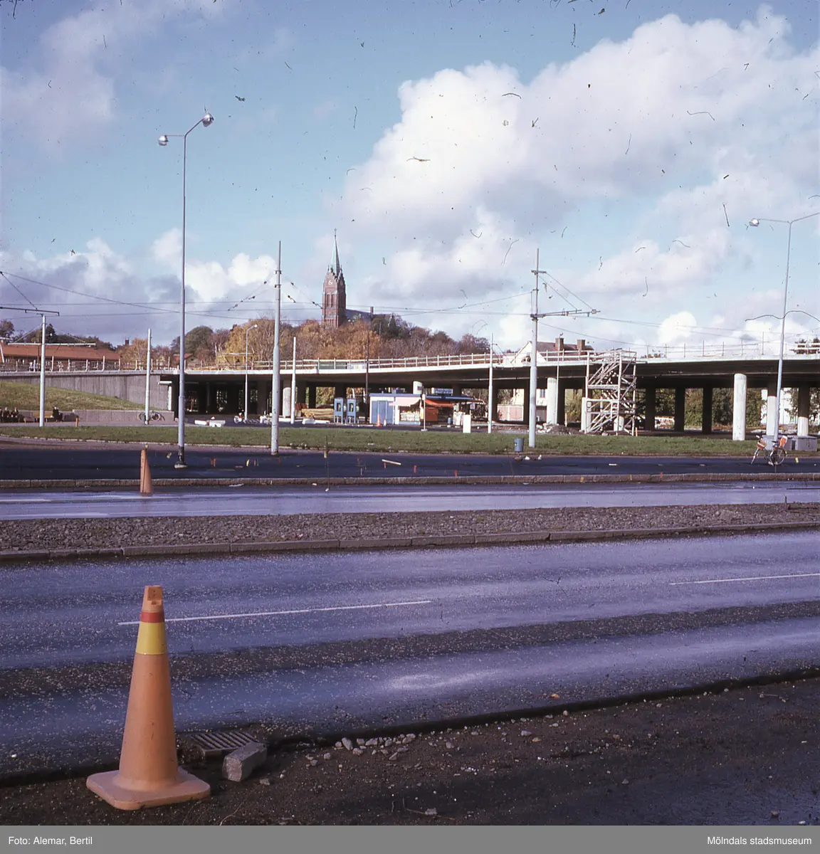 Långt framskriden byggnation av Mölndals bro, ser ut att vara taget under någon gång i början av hösten.
Tid: Cirka början av 1970-talet. 
Bilden visar anläggningsarbete.  
I bakgrunden i mitten skymtar Fässbergskyrkan.