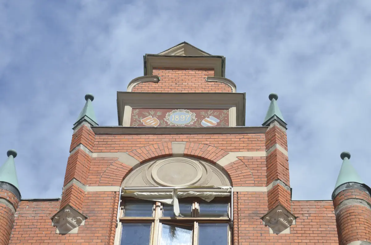 Fasadgavel av rött tegel och målningar i Sundsvalls stenstad