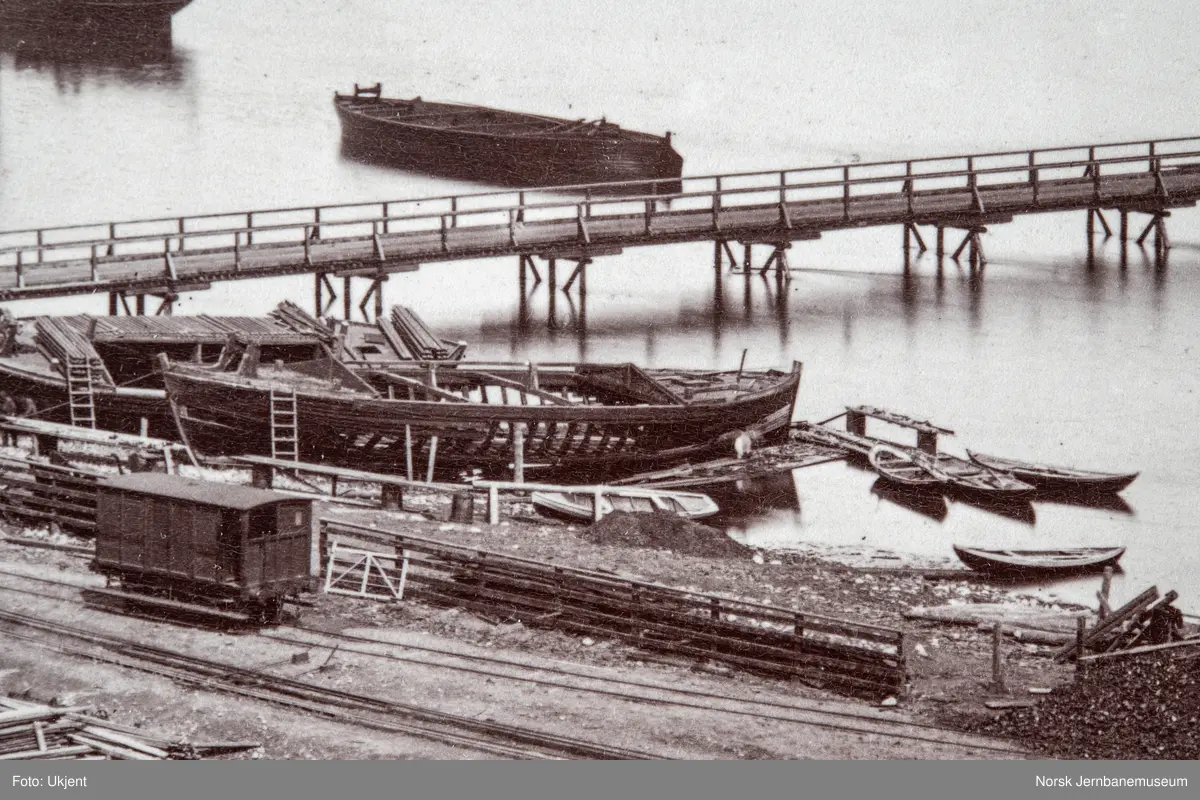 Oversiktsbilde med Eidsvoll stasjon, to dampbåter, beddingen med to klinkbygde lektere og brua over Vorma