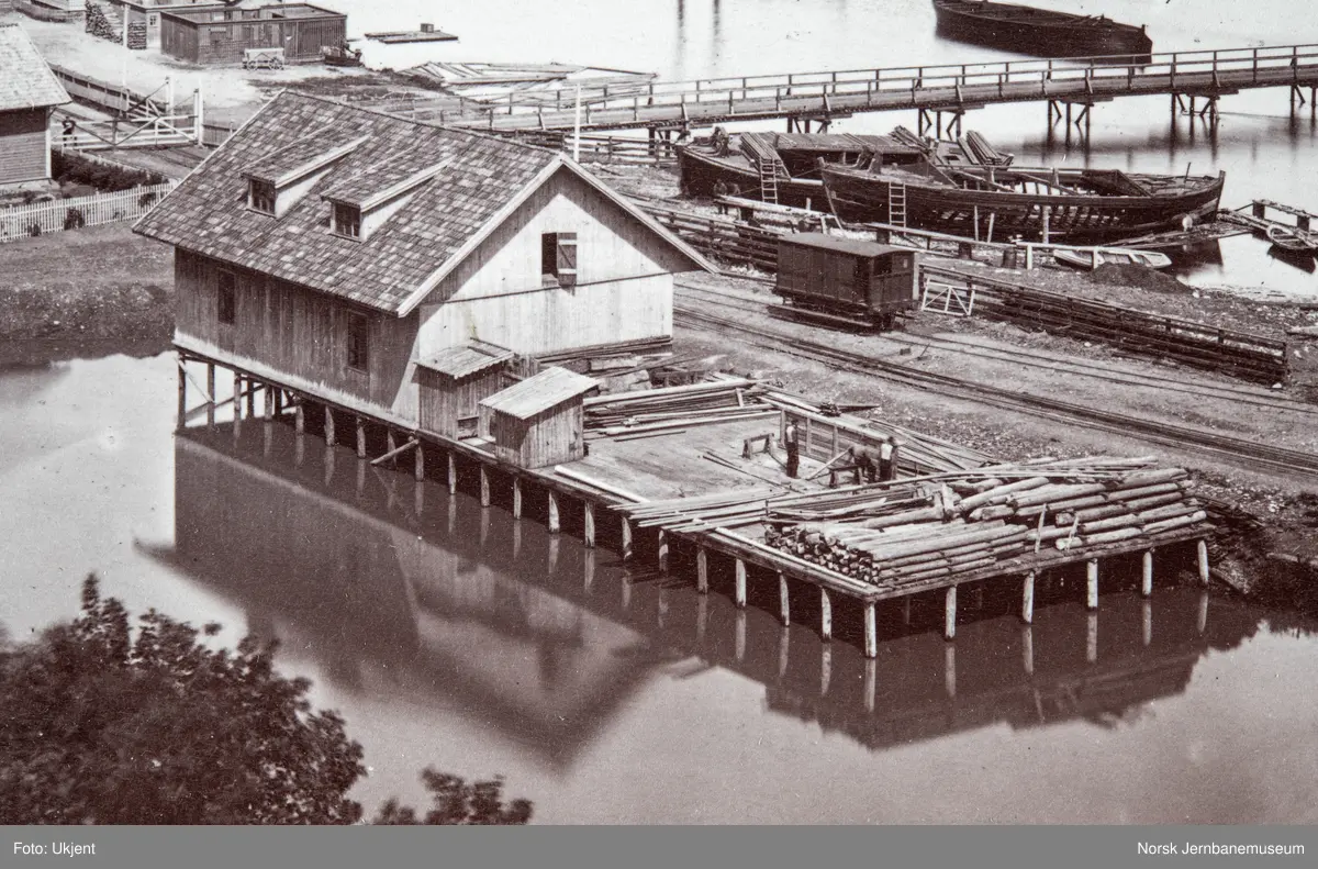 Oversiktsbilde med Eidsvoll stasjon, to dampbåter, beddingen med to klinkbygde lektere og brua over Vorma
