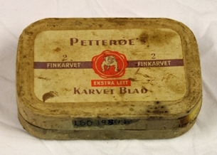 Tobakkseske. Papp med etikett i gult papir på lokk. Rektangulær med avrundede kanter. Brun og hvit skrift. Hvit bulldog med rød sirkulær bakgrunn. 