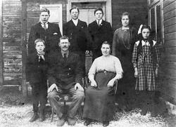 Familiebilde med et sittende eldre par med resten av familie