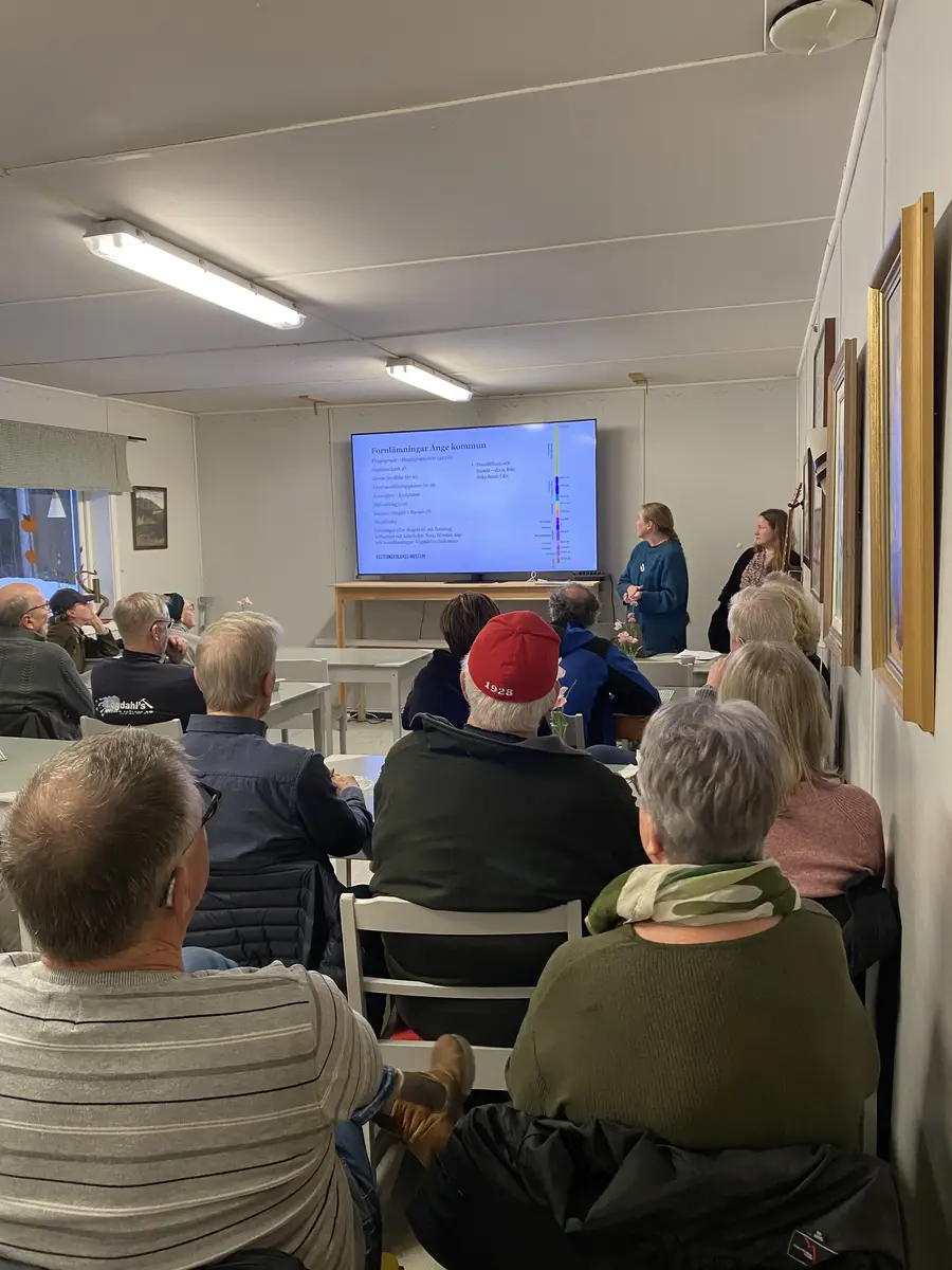 Två personer håller föredrag för en grupp människor