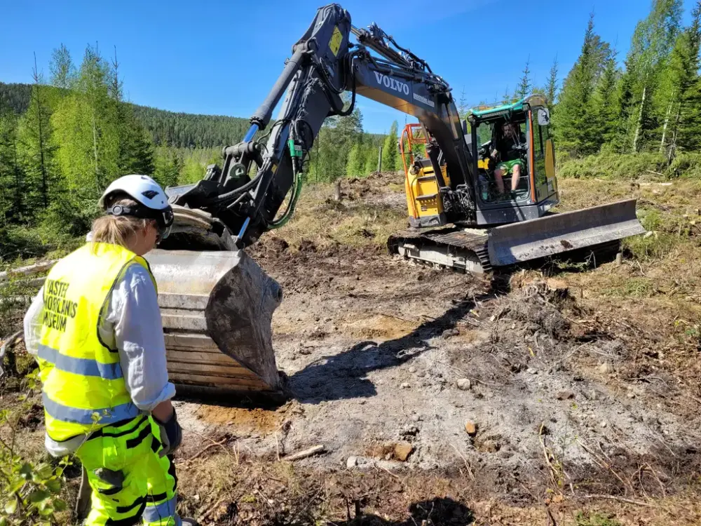 Arkeolog och grävmaskin