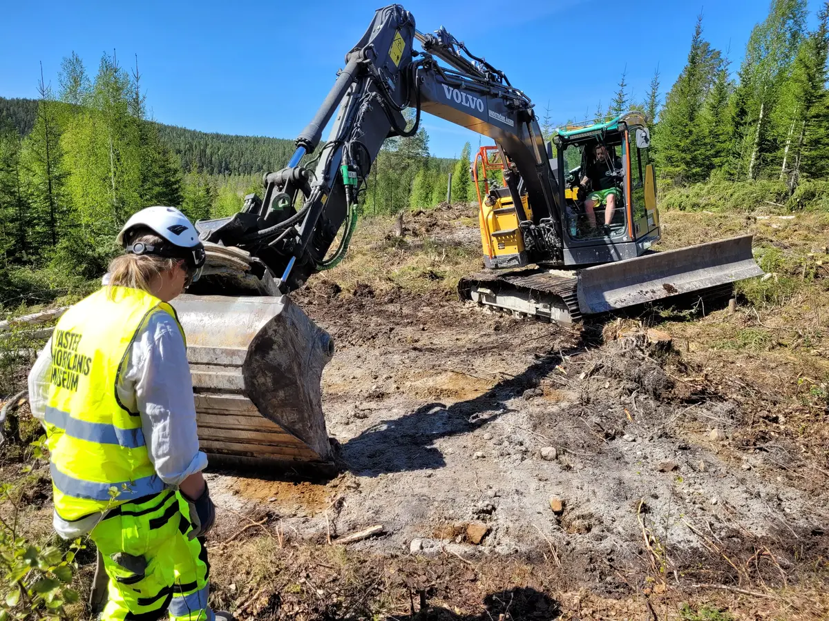 Arkeolog och grävmaskin
