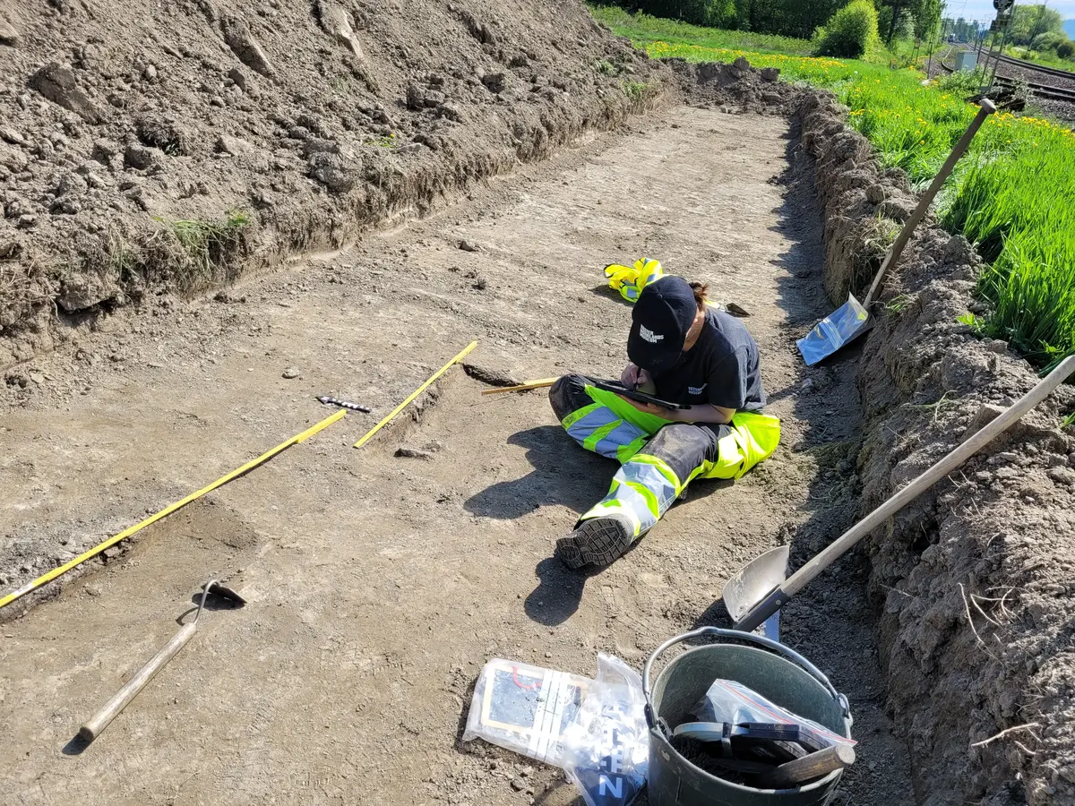 Person sitter i schakt och ritar