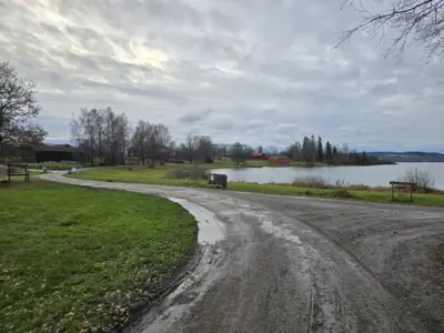 Grusveg som slynger seg mot venstre i retning Løtenbygningen.