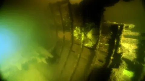 Segelbåtsvrakets insida med tunna spant och bordläggning.