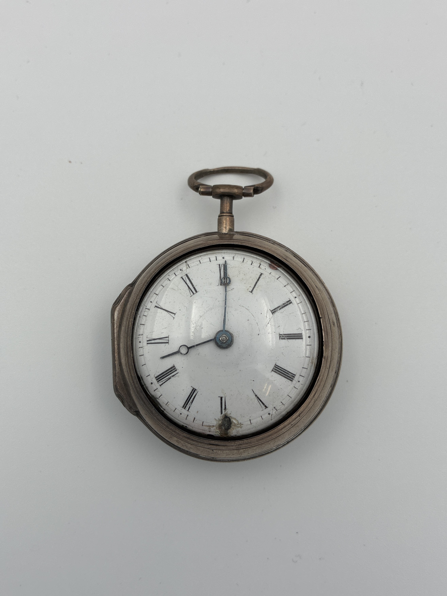 Fickur med osignerat urverk. Inner- och ytter boett av silver med brittiska stämplar. 

Innerboett:
Gående lejon = stämpel för silverhalt
Årsstämpel C = 1758
Ortsstämpel krönt leopardhuvud = London
Namnstämpel S.P

Ytterboett: 
Årsstämpel D = 1759
Ortsstämpel krönt leopardhuvud = London
Namnstämpel S.P