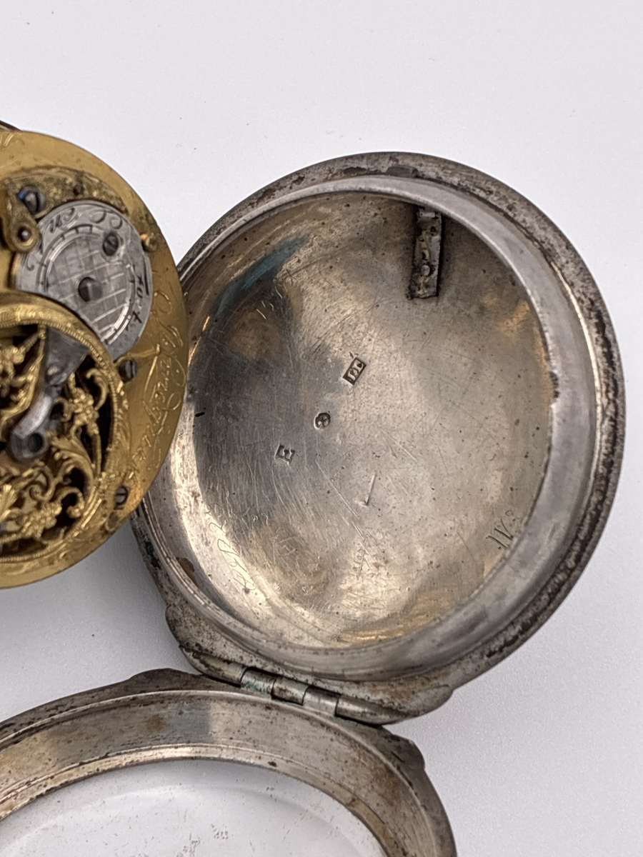 Fickur med urtavla av vit emalj med romerska siffror för timmar och arabiska siffror för minuter. Även signerat Lindquist Stockholm i svart. Urverket signerat "Jh Lindquist Stockholm N: 328" och avser hovurmakare Johan Lindquist (1728-1779). 

Boett av silver med stämplar: 
Mästarstämpel: IL = Johan Lindqvist 
Årsbokstav: E = 1763
Kattfot/tre kronor