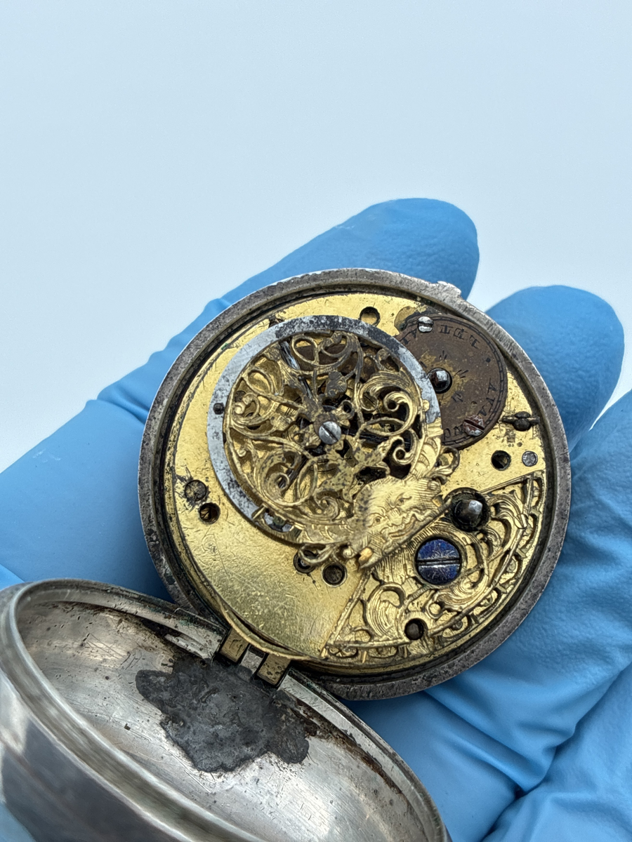 Fickur med osignerat urverk. Inner- och ytter boett av silver med brittiska stämplar. 

Innerboett:
Gående lejon = stämpel för silverhalt
Årsstämpel C = 1758
Ortsstämpel krönt leopardhuvud = London
Namnstämpel S.P

Ytterboett: 
Årsstämpel D = 1759
Ortsstämpel krönt leopardhuvud = London
Namnstämpel S.P