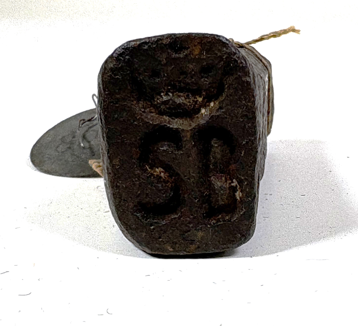 Rektangulärt metallstycke med en cirkelformad slagyta i ena änden. Den andra änden är något bredare och har en instansad text "SB" krönt med en kungakrona.