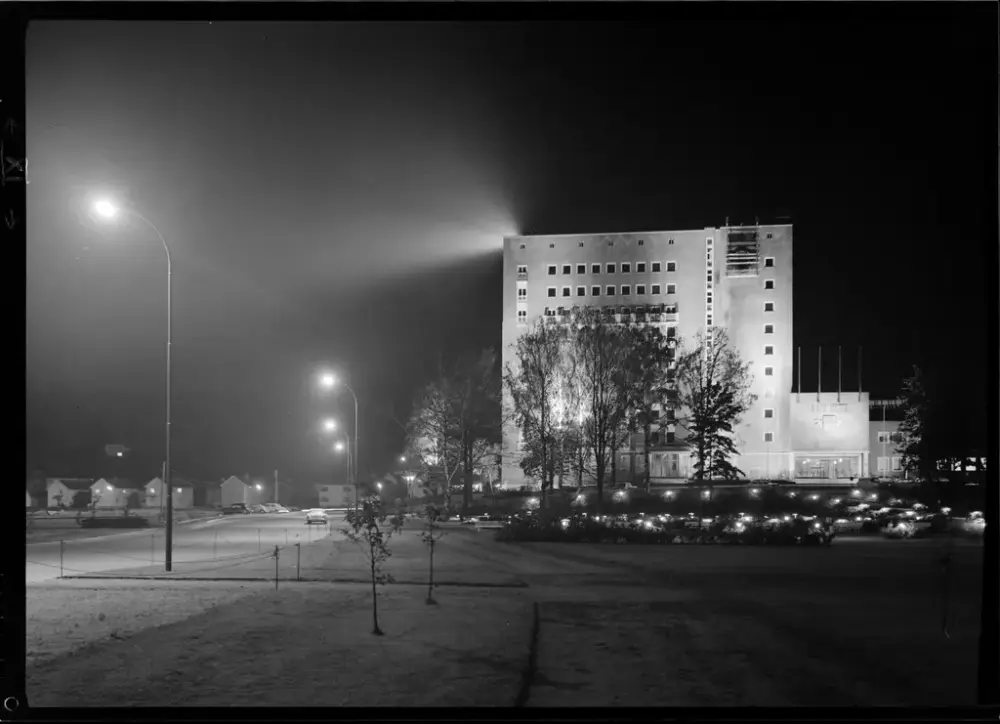 Sort-hvit-bilde som viser et opplyst høybygg i mørket