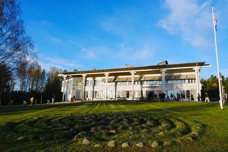 Museibyggnaden i höstsol, med labyrinten i gräset framför.