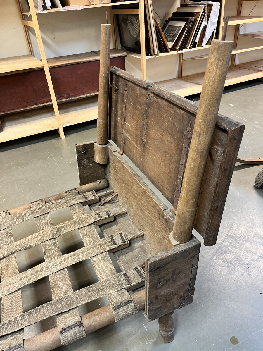 Form: Har form av ei "topseng".
1 topseng i kasse.

En slags fæltseng i form av en topseng. Kassen av eketræ. Umalt. Kassen har hat laas, der nu mangler.

