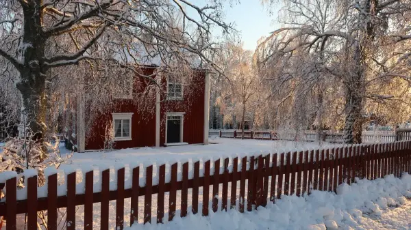 Skolbyggnaden på friluftsmuseet under en snöig vinter.