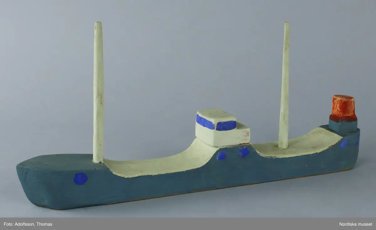 Lastfartyget är tillverkat i skolslöjden, troligen bemålat med limfärg i blått och vitt. Två vita master, en röd skorsten samt kommandobrygga.