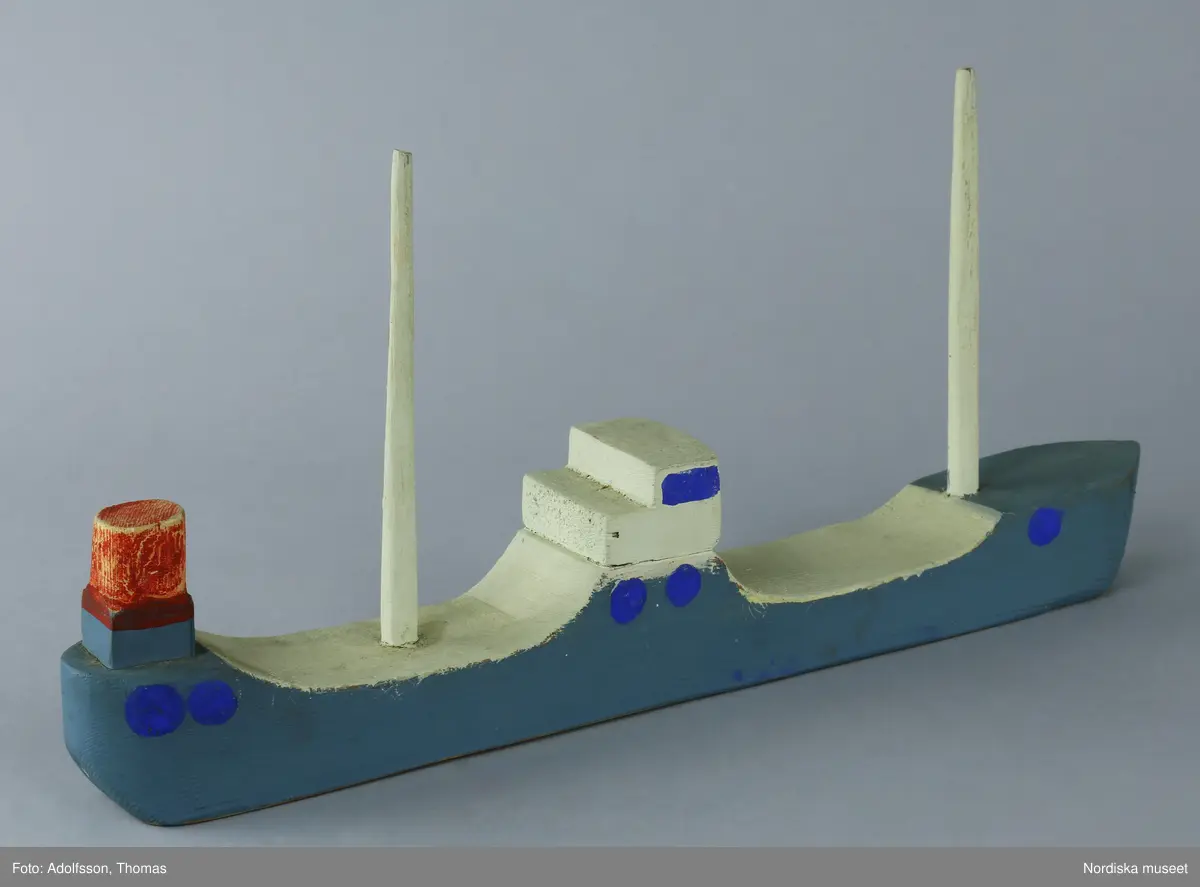 Lastfartyget är tillverkat i skolslöjden, troligen bemålat med limfärg i blått och vitt. Två vita master, en röd skorsten samt kommandobrygga.