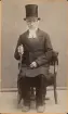 Porträtt av en sittande man i prästkläder. Text baksida kort: 