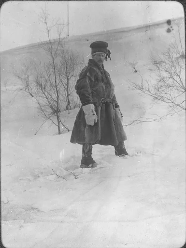 En mann kledt i pesk står i en bakke.