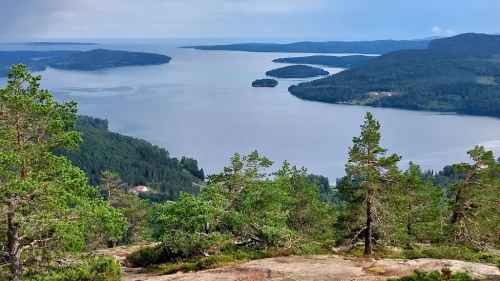 Utsikt från ett berg över ett vattendrag med öar och holmar.