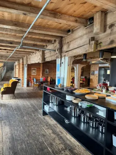 Vi ser et nydelig sjøbodlokale, med flotte møbler fra en svunnen tid, en svart disk hvor det står fristende lapper og kaffe.