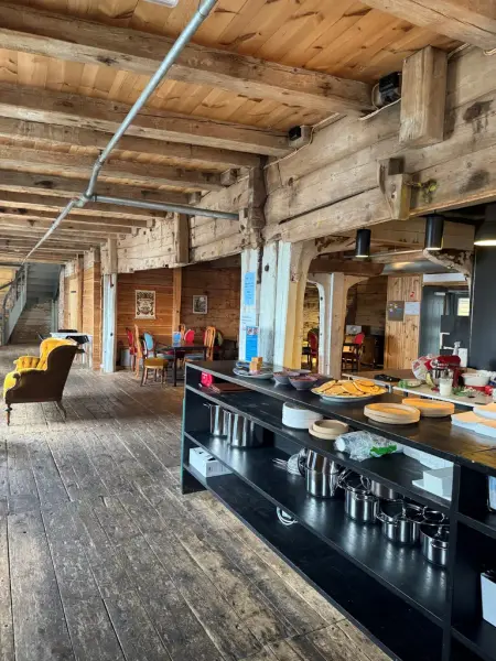 Vi ser et nydelig sjøbodlokale, med flotte møbler fra en svunnen tid, en svart disk hvor det står fristende lapper og kaffe.