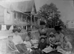 En gruppe mennesker, både voksne og barn foran et hus til ve