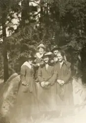 Fem unga kvinnor på skogspromenad, en solig vårdag.
På baksi