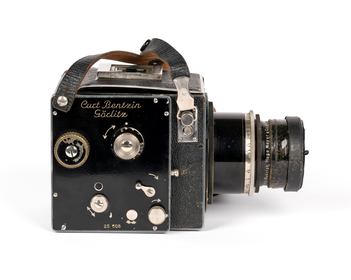 Primarflex 6x6 kamera med polstret skinnveske, bruksanvisning og 2 filter.
Objektiv/ Linse: D.R.P.Dr.Rudolph Hugo Meyer & Co Görlitz Nr. 584973. MakroPlasmat 1:27, f=10.5 cm.

Metallkropp dekt med lær på utsiden. Skinnreim. På toppen en belg som spretter opp ved å trykke på en liten knapp. Ellers flere justeringsknapper på høyre side.
Serienummer: 25608.