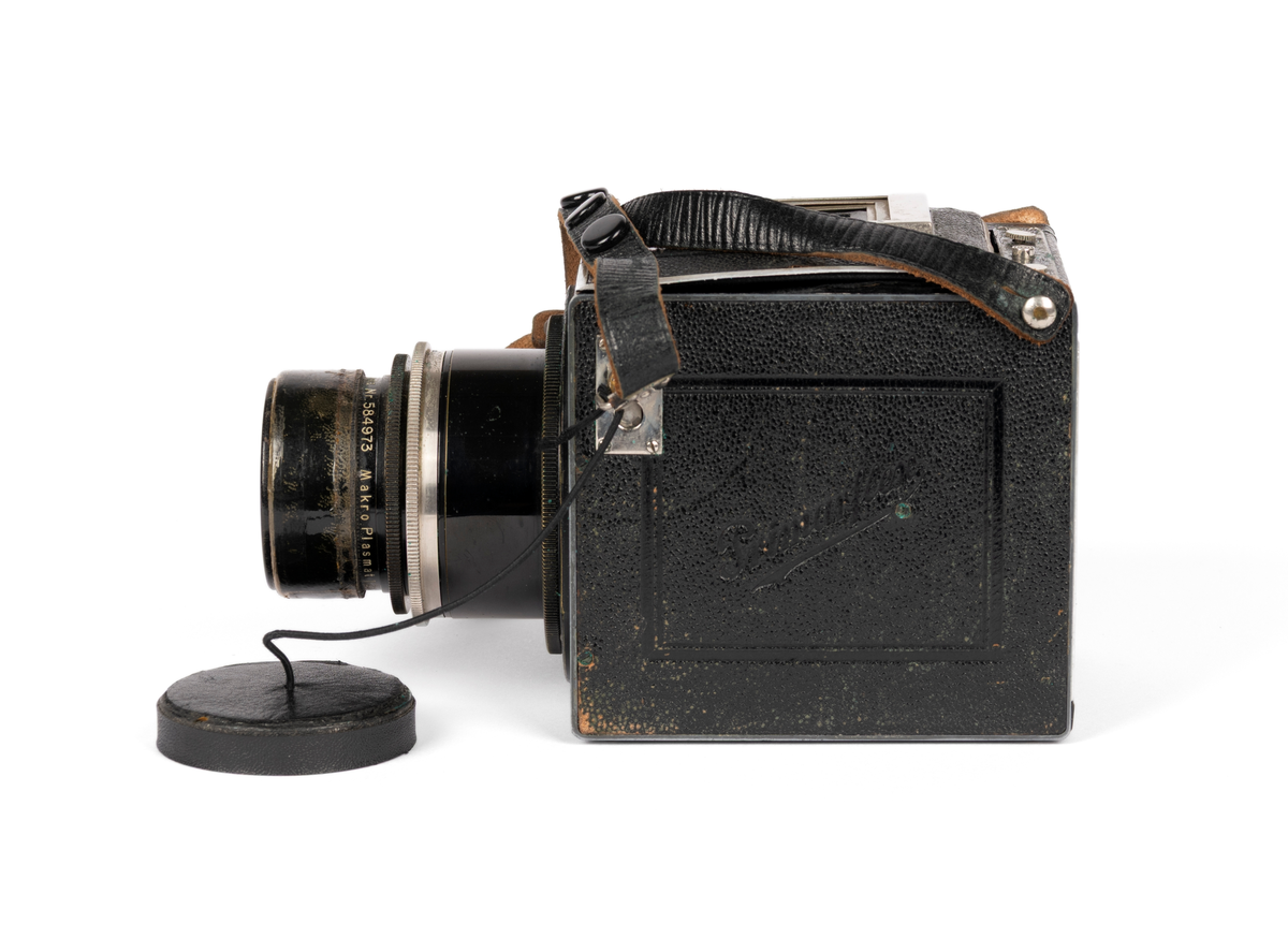Primarflex 6x6 kamera med polstret skinnveske, bruksanvisning og 2 filter.
Objektiv/ Linse: D.R.P.Dr.Rudolph Hugo Meyer & Co Görlitz Nr. 584973. MakroPlasmat 1:27, f=10.5 cm.

Metallkropp dekt med lær på utsiden. Skinnreim. På toppen en belg som spretter opp ved å trykke på en liten knapp. Ellers flere justeringsknapper på høyre side.
Serienummer: 25608.